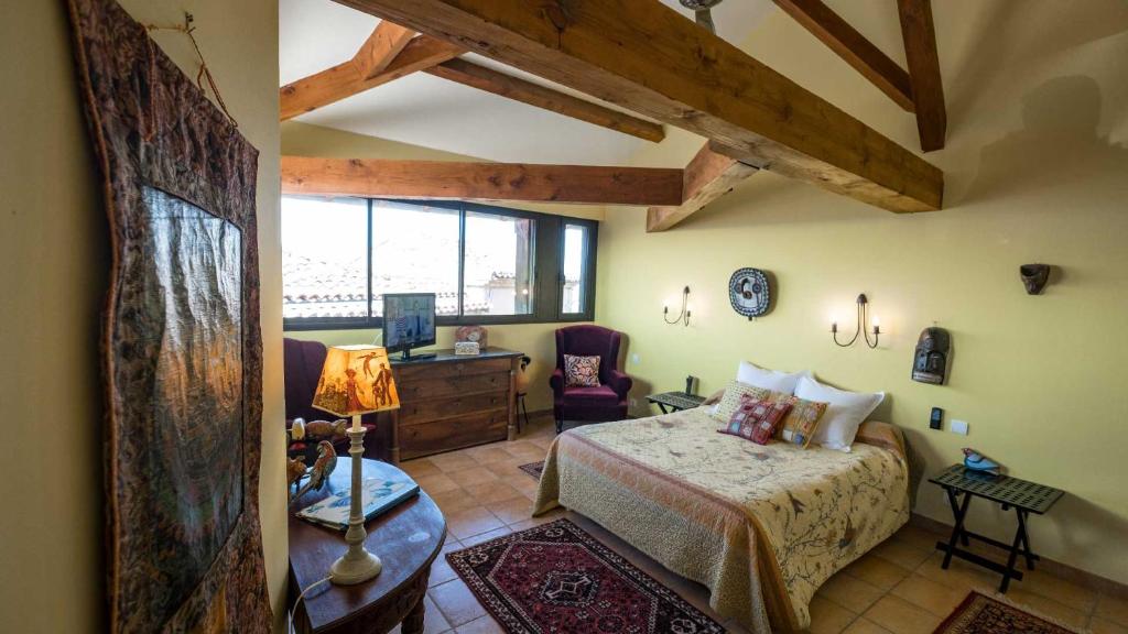 Chambre sous les poutres, vue sur les toits — © L'Ancienne Auberge